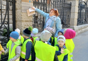 Pani Marzenka opowiada dzieciom przed jakim stoją budynkiem.