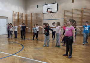 Przedszkolaki podczas zajęć na sali gimnastycznej.