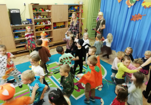 Dzieci w jesiennych kostiumach tańczą do piosenki "Wiewióreczka mała".