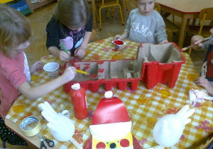 dzieci malują pudełko z którego wykonany zostanie pojazd św. Mikołaja