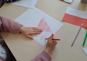 Dzieci wykonują pracę plastyczna na temat "Co kojarzy mi się z Polską?"