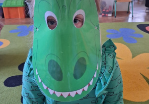 Dziewczynka przebrana za dinozaura.