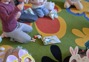 Przedszkolaki otwierają prezenty od zajączka.